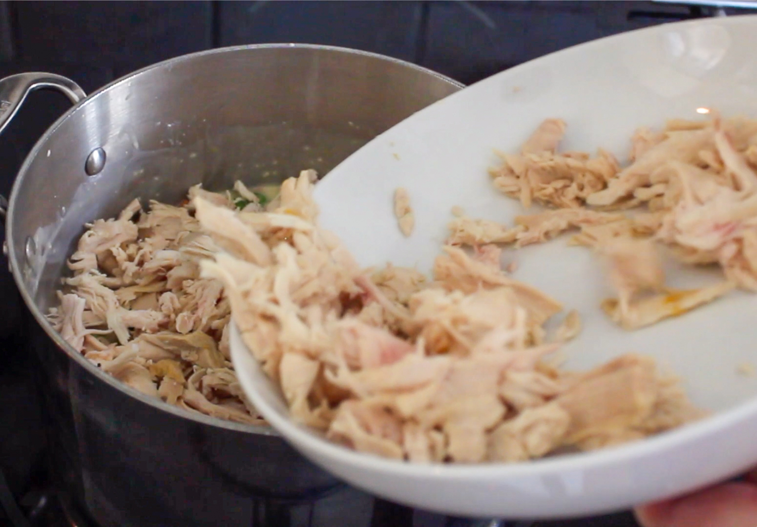 adding shredded chicken breast to a pan