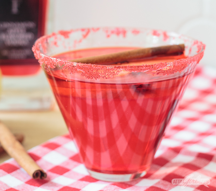 Sugar rimmed cinnamon apple martini on a red and white tablecloth