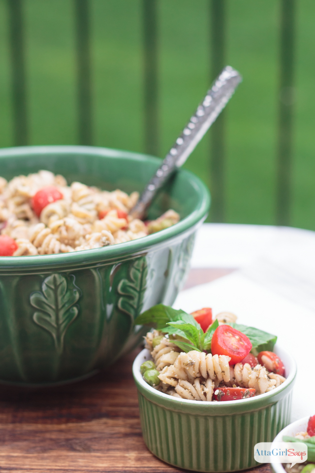 green bowl and ramekin with pesto pasta salad