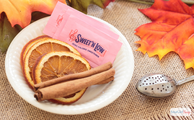 ironstone bowl with sweet 'n low packets, dried orange slices and cinnamon sticks