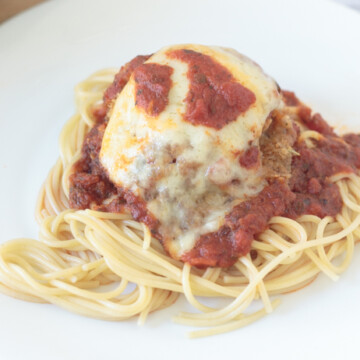 chicken parmesan over spaghetti noodles