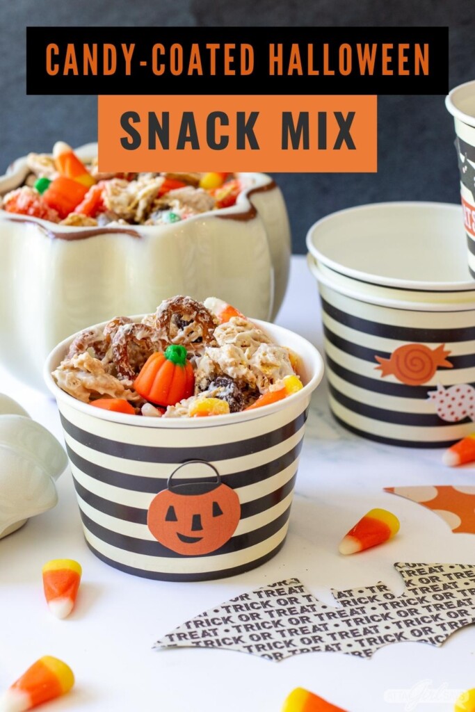 party table with Halloween snack mix and Halloween decorations