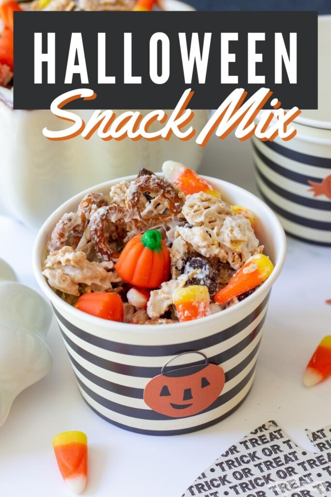 black and white striped cup filled with Halloween snack mix