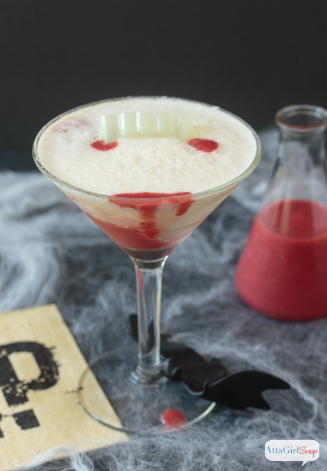 martini glass with pina colada cocktail with drops of strawberry puree