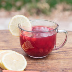glass mug of cranberry spiced tea with lemon garnish