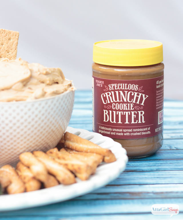 jar of cookie butter next to a plate of pretzels and cookie butter dip