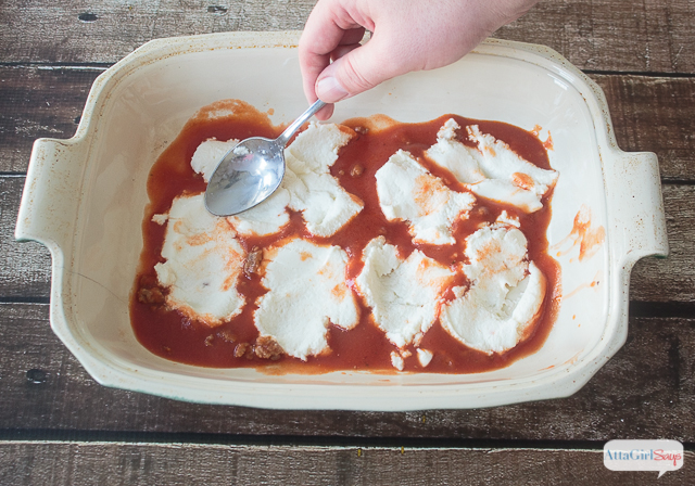 adding cheese and sauce to a casserole dish to make lasagna
