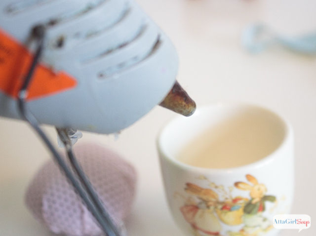 Use a hot glue gun to secure the pin cushion in the egg cup. 