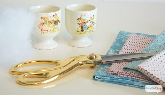 scissors, fabric, egg cups and fiberfill - supplies to make Easter egg cup pin cushions