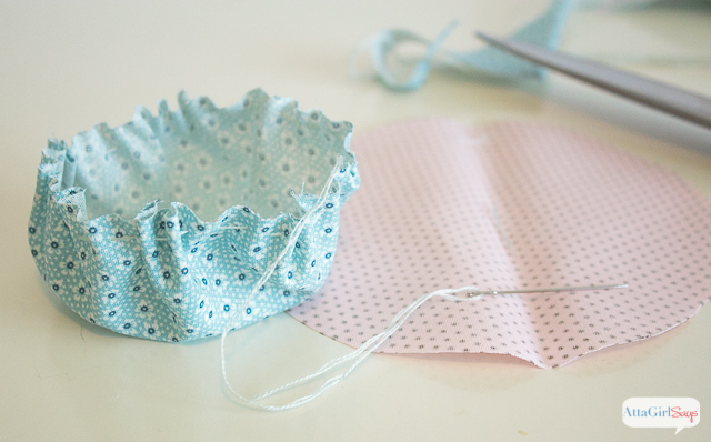 As if you were making a yo-yo out of fabric, sew a running stitch around the edge of your fabric circle. Then pull to gather. You'll fill this to make your Easter egg cup pin cushion.