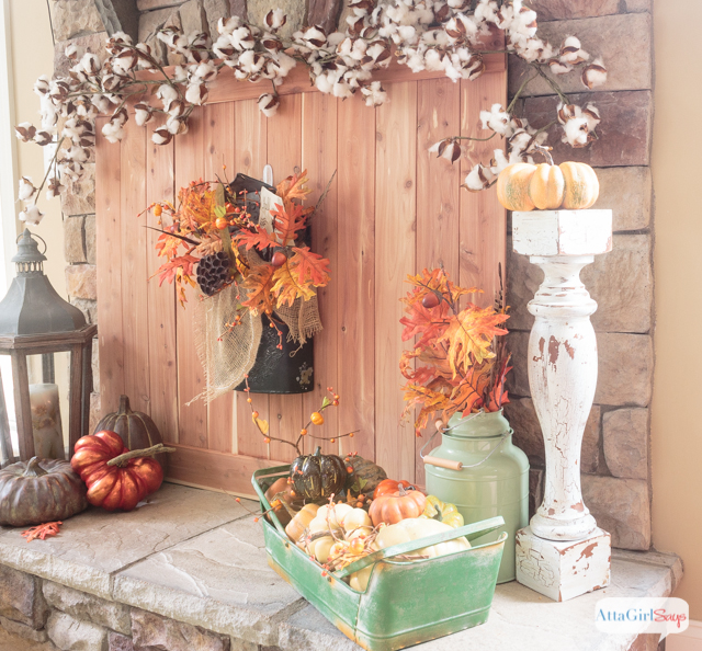 These fall fireplace mantel decorating ideas combine cedar wood, cotton bolls, pumpkins, lanterns and colorful fall leaves. The design is inspired by a rustic fall harvest.