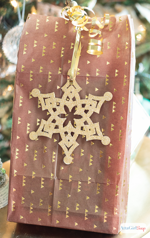 You don't need expensive paper or fancy ribbon to wrap beautiful gifts. Check out these inexpensive Christmas gift wrapping ideas, including tips for dressing up plain wrapping paper, a tutorial to make make glittery package toppers and a technique for making gift bags out of any kind of paper you have on hand. #ad #decoartprojects 