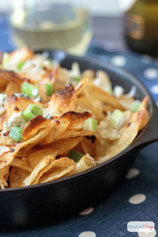 potato chips topped with cheese and onions in an iron skillet