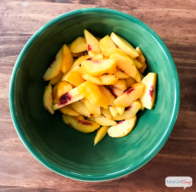 Fresh peach slices in a bowl ready to be used in peach trifle icebox cake.
