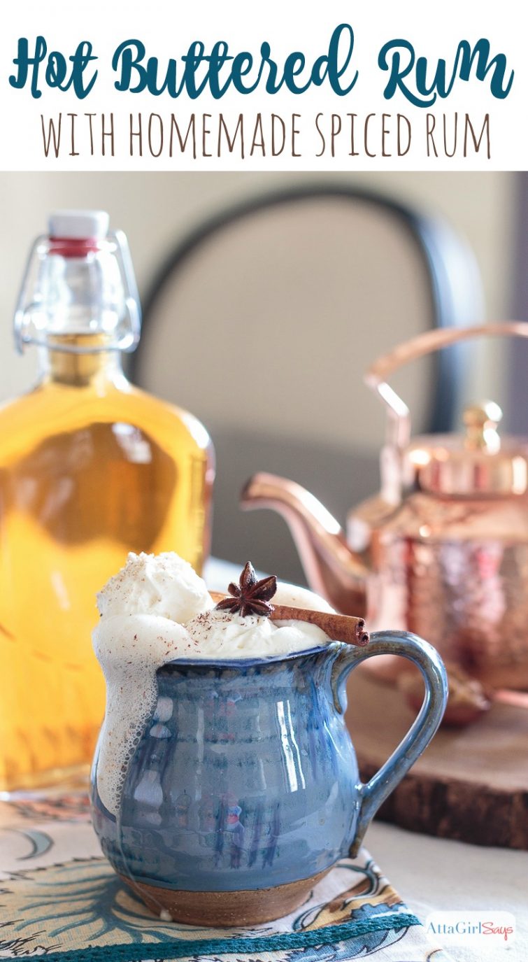 mug of hot buttered rum with rum bottle and copper teakettle in the background
