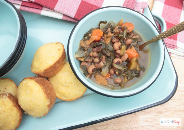 overhead shot of a bowl of black eyed pea soup and cornbread muffins