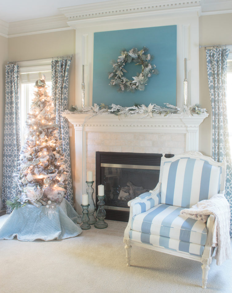 Stunning blue-and-white Christmas decorations featuring a flocked tree, mercury glass, birds and snowy branches. So many wonderful Christmas mantel ideas here. #sponsored #AtHomeStores