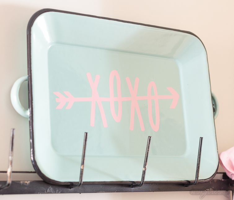 Dress up your coffee mug wall rack with simple Valentine's Day decor, including a "Gossip Girl" inspired quote you can make with your Cricut. Enamel coffee mugs, miniature boxwood wreaths and heart-shaped plates! Swoon. Click for sources to recreate this look! #mugrack #valentinesday #gossipgirl #xoxo #farmhouse #aquaandpink #mugrackmonday #valentinesdecor #cricutmade #cricutmaker #cricutexploreair #quotes