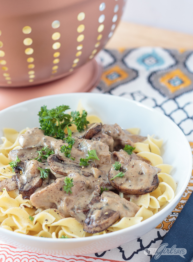 slow cooker beef stroganoff in a bowl with egg noodles and mushrooms