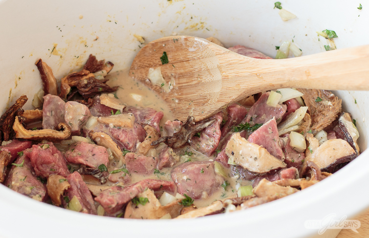 beef, mushrooms and onions in a slow cooker 