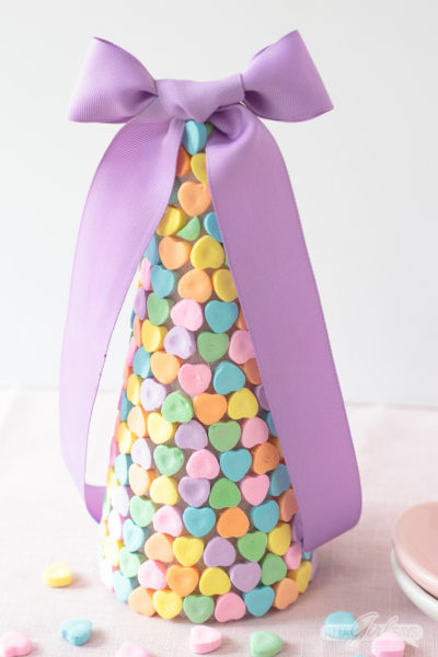 Add a sweet touch to your holiday table with these cute and easy-to-make Valentine candy heart centerpieces made with conversation hearts. #valentinesday #candyhearts #conversationhearts #valentinescrafts #centerpiece