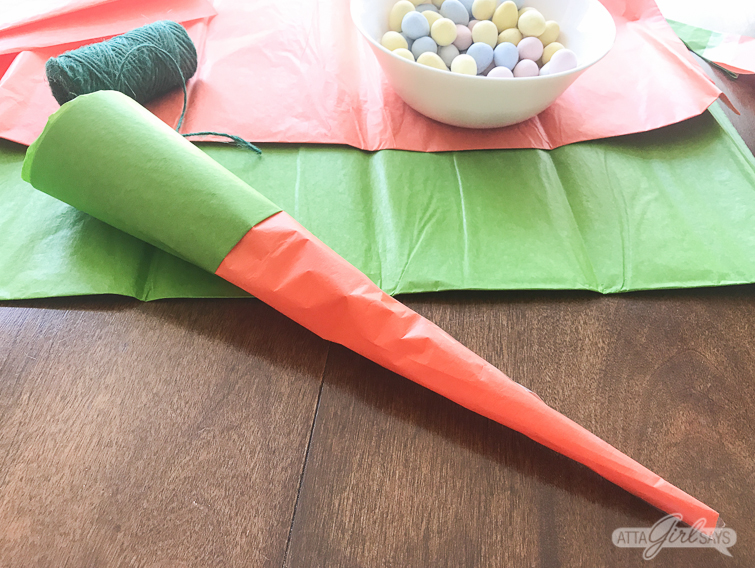 These tissue paper carrots hide a tasty surprise inside. Fill them with miniature chocolate eggs, jelly beans, M&M's or another favorite Easter candy. Click for step-by-step instructions, plus a supply list to make this adorable, edible Easter basket craft. #Easter #tissuepaper #carrots #eastercrafts