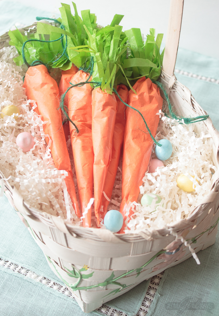 These tissue paper carrots hide a tasty surprise inside. Fill them with miniature chocolate eggs, jelly beans, M&M's or another favorite Easter candy. Click for step-by-step instructions, plus a supply list to make this adorable, edible Easter basket craft. #Easter #tissuepaper #carrots #eastercrafts