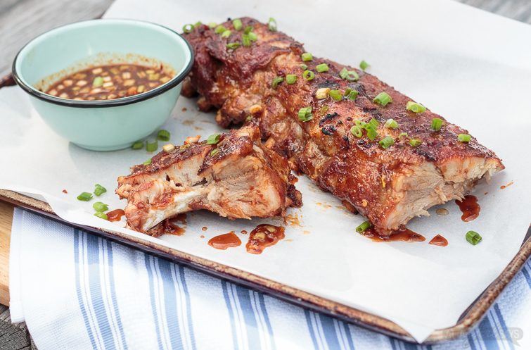 These Asian sweet & spicy grilled baby back ribs are going to be the star of your next cookout! Seasoned with a delicious homemade spice rub and slow cooked on the grill until they're fall-off-the-bone tender, the ribs are finished with a maple chili garlic sauce. You'll feel like a champion pitmaster every time you serve these! #ad #GetGrillingAmerica #ribs #grilledribs