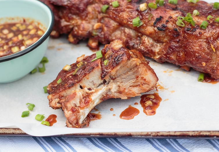 These Asian sweet & spicy grilled baby back ribs are going to be the star of your next cookout! Seasoned with a delicious homemade spice rub and slow cooked on the grill until they're fall-off-the-bone tender, the ribs are finished with a maple chili garlic sauce. You'll feel like a champion pitmaster every time you serve these! #ad #GetGrillingAmerica #ribs #grilledribs