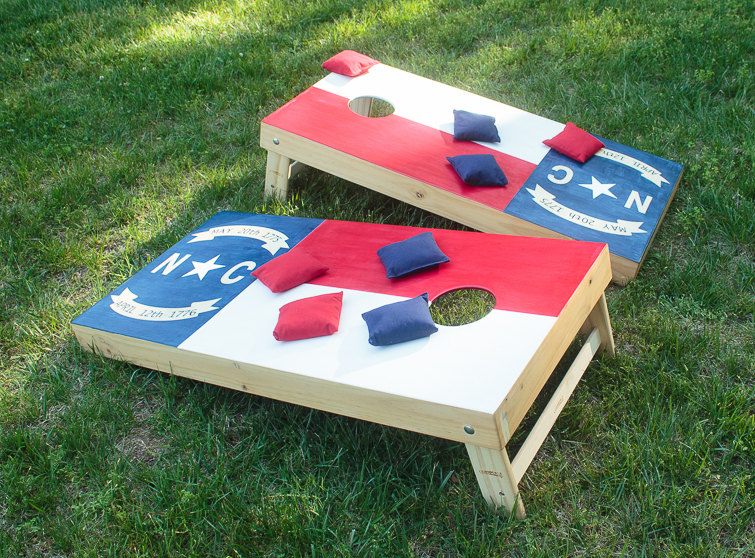 Create your own custom cornhole boards using colored stain and FrogTape. Click for the step-by-step directions on how to make this North Carolina state flag cornhole board design. #ad #cornhole #NCflag #yardgames #summerfun
