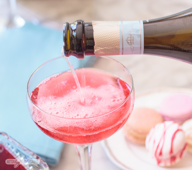 Pouring La Marca Prosecco into a coupe glass to make a pink blooming hibiscus cocktail. This is such a fun drink to make at your next brunch! Click for the recipe + 2 more versions. #ad #CelebratorySips #CelebrateWithLaMarca