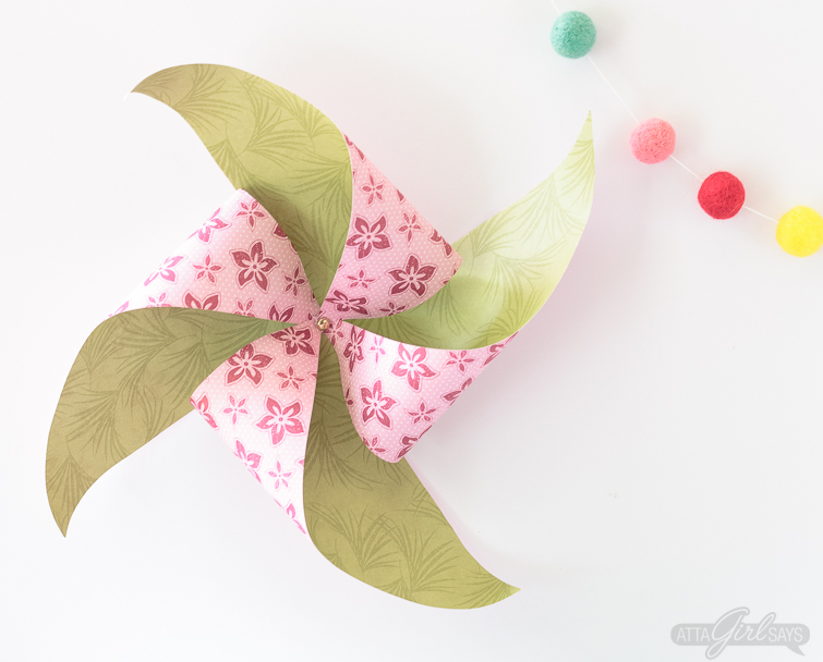 Learn how to make a pinwheel using a full sheet of scrapbook paper. Hang larger pinwheels on the wall or on your front door to create an instant party vibe! #papercrafts #pinwheels #scrapbookpaper #papercrafting 