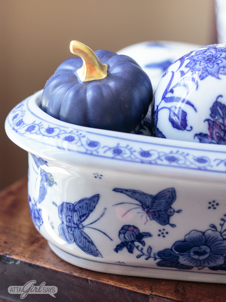 blue ceramic pumpkin and blue and white chinoiserie balls in a blue and white butterfly planter
