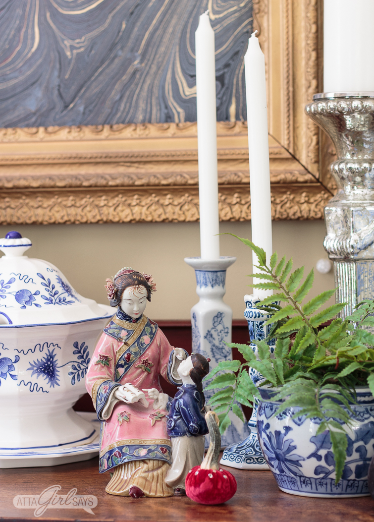 chinese figurine and blue and white chinoiserie pottery on a sideboard