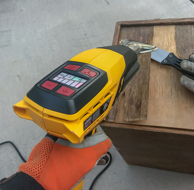 using a heat gun and a putty knife to remove veneer from a vintage card catalog