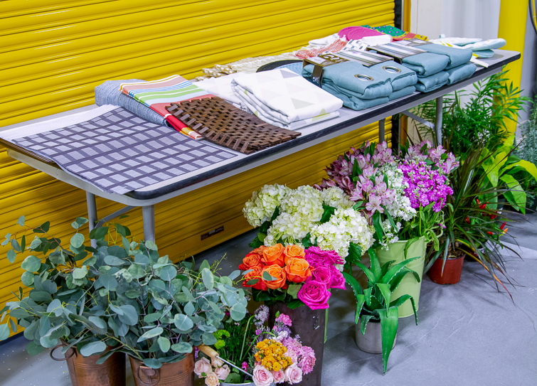 linens and fresh flowers set up on a table and the floor in a warehouse