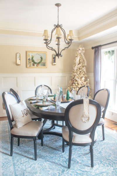 formal dining room decorated for Christmas with a gold tree