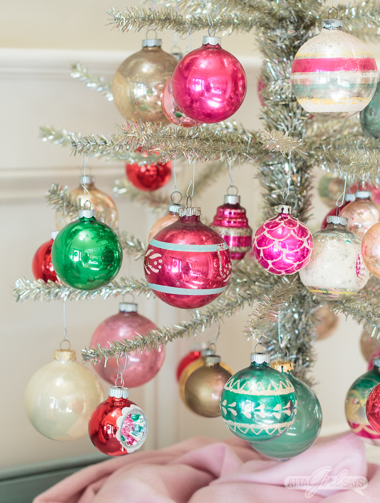 feather tinsel Christmas tree decorated with pink and green Shiny Brite ornaments on top of an aqua buffet