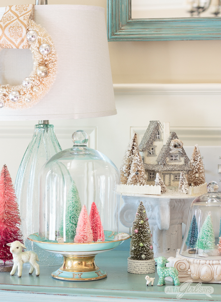 colorful bottle brush Christmas trees in pastel colors on top of an aqua painted buffet