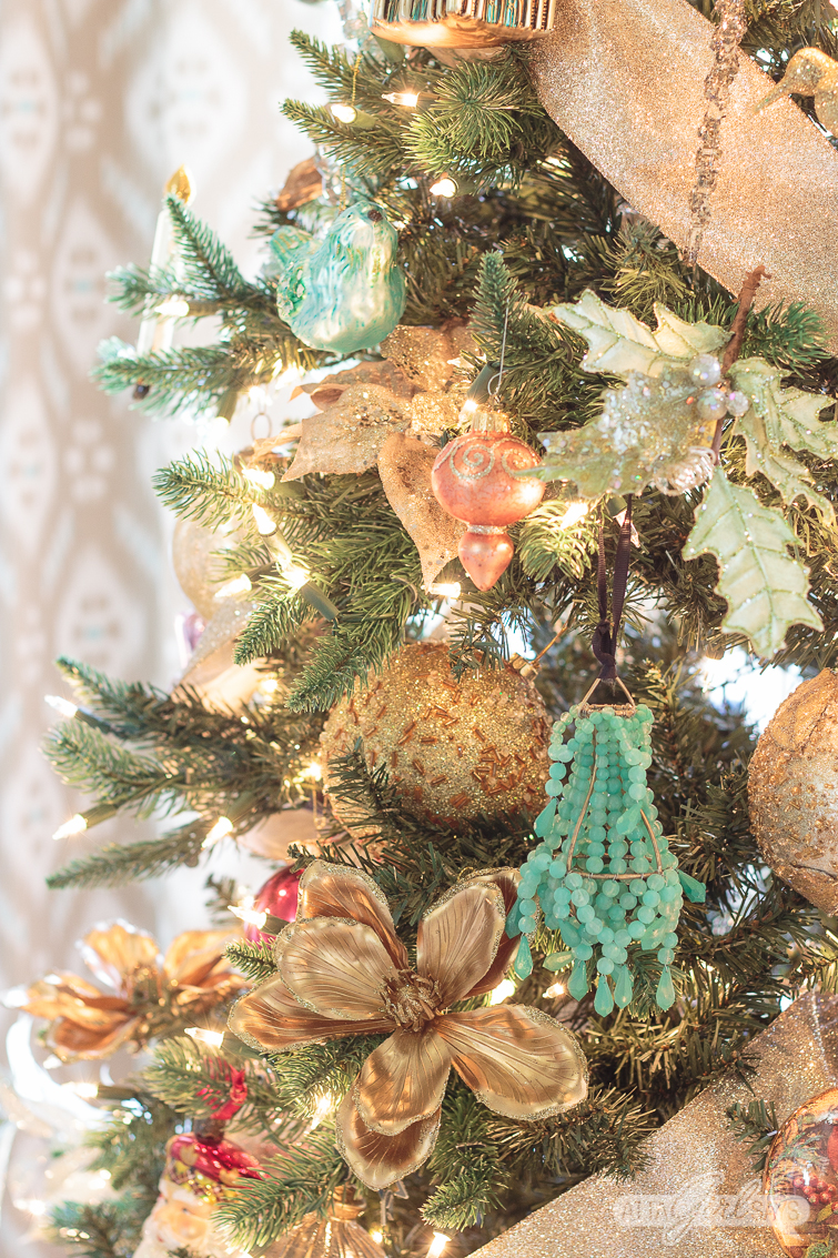 pink, green and gold ornaments on a Christmas tree decorated with gold ribbon