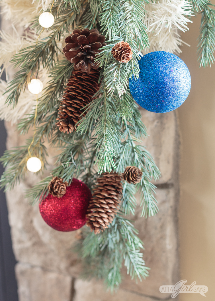 green and white Christmas garland decorated with red and blue ornaments and ball lights