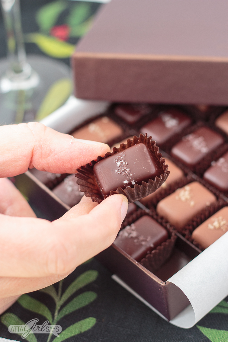 man's hand holding a chocolate salted caramel candy