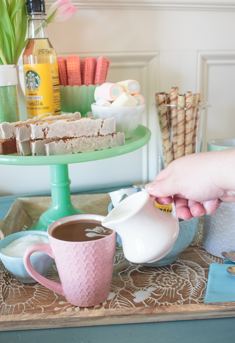 pouring cream into a mug of coffee at a coffee bar