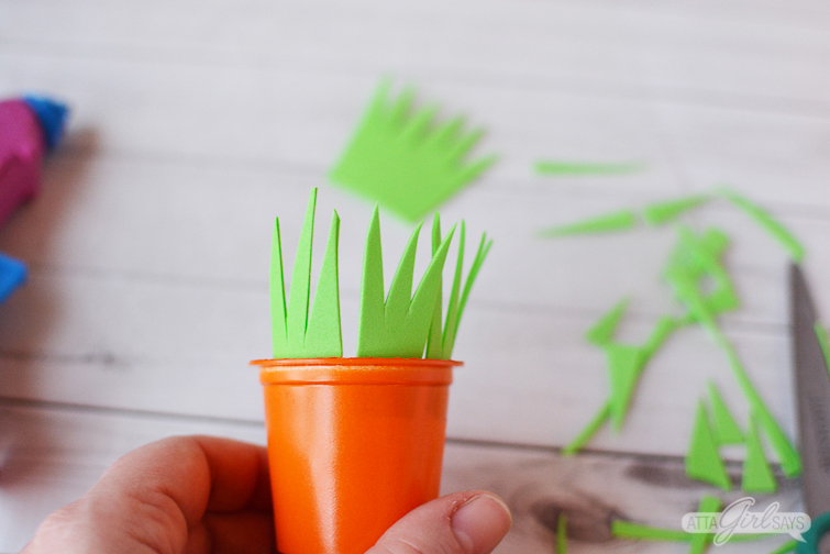 attaching foam grass to the tops of recycled K cup Easter carrot treat cups