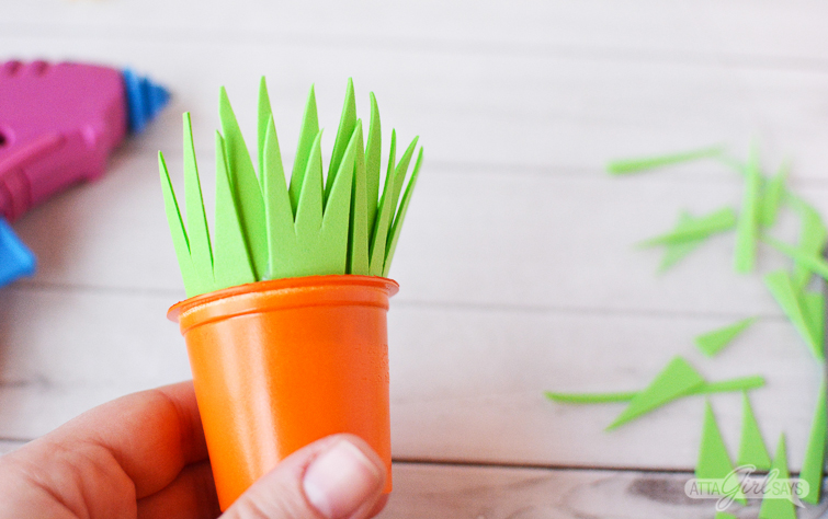 attaching foam grass to the tops of recycled K cup Easter carrot treat cups