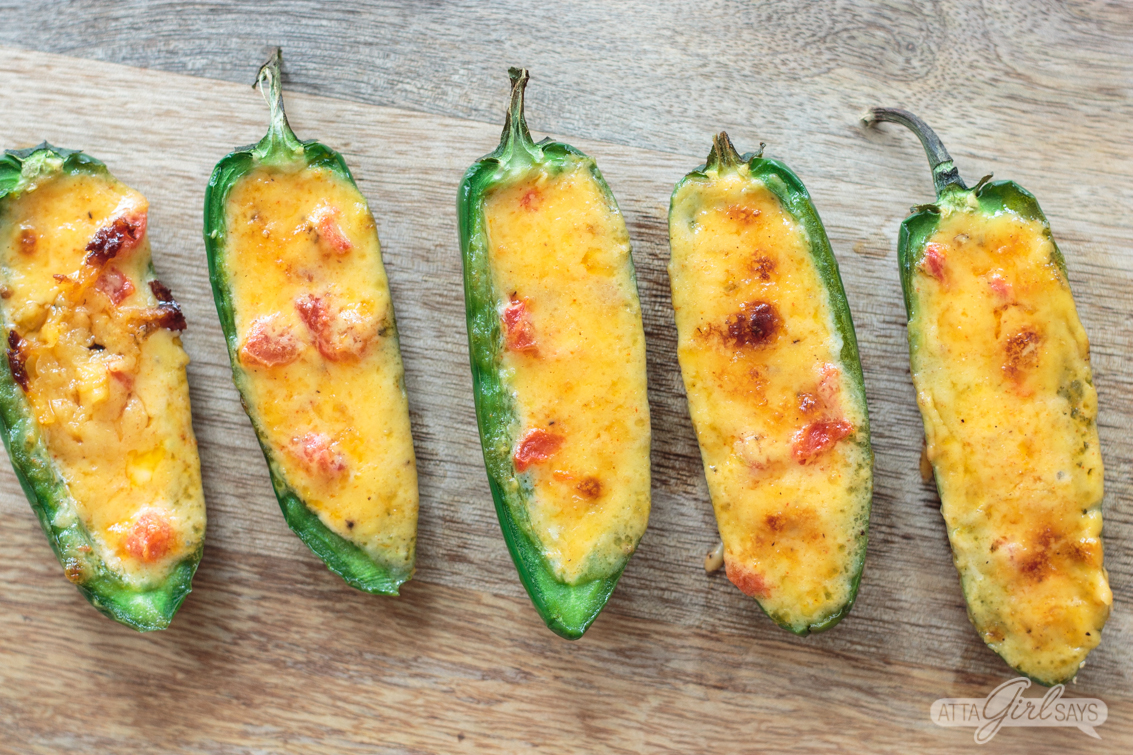pimento cheese stuffed baked jalapeno peoppers on a cutting board