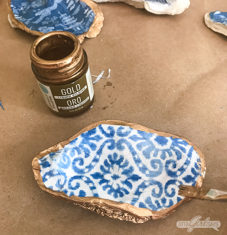 applying liquid gold leaf to the edges of chinoiserie oyster shells