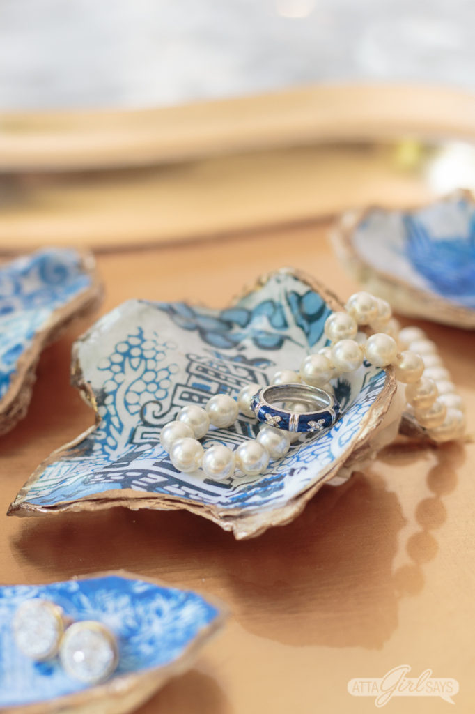 blue and white chinoiserie oyster shell jewelry dish with a pearl necklace resting on it