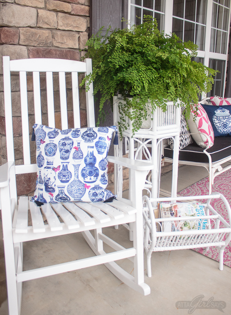 front porch decorated with white Hollywood regency furniture, a pink rug and blue chinoiserie pillows