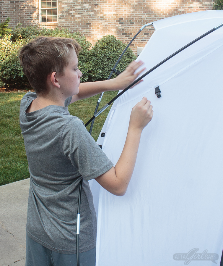 boy putting up a spray shelter tent